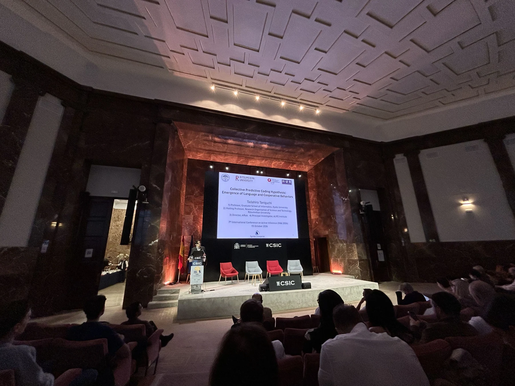 Tadahiro Taniguchi presenting at IWAI 2026